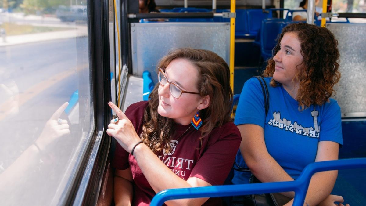 两个学生在公共汽车上望着窗外